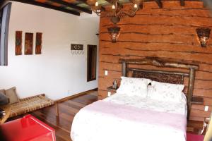 a bedroom with a bed and a brick wall at Pousada Toque Mineiro in Tiradentes +75 photos