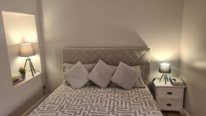 a bedroom with a bed with pillows and two lamps at Casa da Avó Duca in Machico