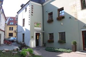 a white building with flowers on the side of it at Apple Economy Hotel in Kaunas