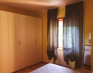 a bedroom with white cabinets and a window at Elena Rooms in Campobasso