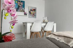 sypialnia ze stołem i 2 białymi krzesłami w obiekcie apartamento plaza del parque w mieście Villanueva de Arosa