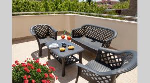 a patio with three chairs and a table with drinks on it at Hotel Le Querce in Senigallia