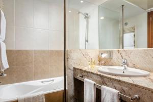 a bathroom with a sink, mirror, and bathtub at Eurostars Andorra in Andorra la Vella