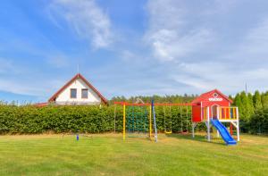 a playground with a swing set and a house at Compass House in Wisełka
