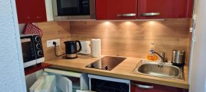 a kitchen counter with a sink and a microwave at Appartement d'une chambre avec vue sur la ville balcon et wifi a Chamrousse in Chamrousse