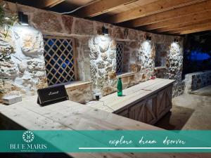 een stenen kamer met een tafel en een fles wijn bij Blue Maris in Sutomore