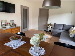 uma sala de estar com uma mesa e um sofá em WOHNUNG ERDGESCHOSS mit 3 Schlafzimmer in ruhiger Gegend em Mäder