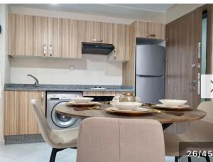 a kitchen with a table with chairs and a refrigerator at Oceanica by Smir Park luxury apartment Marina Smir in M'diq