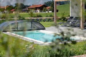 a swimming pool in a yard with chairs and a house at Inzell Chalets by ALPS RESORTS in Inzell