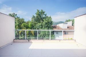 a balcony with a white fence and trees at Condomínio Juquehy in Juquei