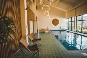 a swimming pool with two chairs and a chandelier at Turističko naselje Natura Art-Hotel Opal Art in Lohovo