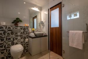 a bathroom with a toilet and a sink and a shower at Salcete Beach Resort in Colva