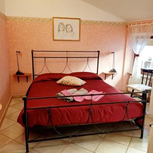 a bedroom with a bed with a red comforter at B&B Brunamonti in Arcevia