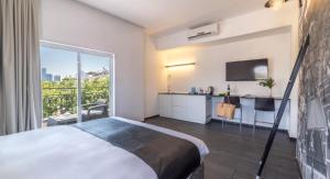 um quarto de hotel com uma cama e uma grande janela em Dizengoff Avenue Boutique Hotel em Tel Aviv