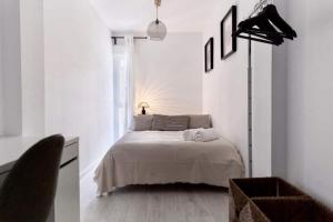 a white bedroom with a bed and a window at Casa Mariel in Málaga