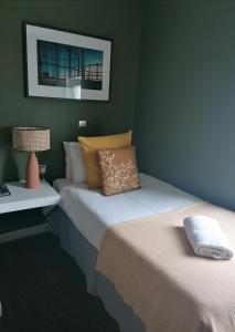 1 dormitorio con 2 camas y mesa con lámpara en Old Ship Inn Hackney en Londres