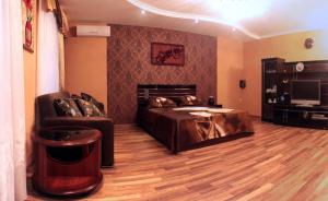 a bedroom with a bed and a couch and a television at Welcome to Poltava Apartments in Poltava