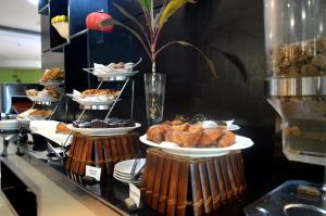 a buffet line with plates of pastries and other food at Best Western Premier Accra Airport Hotel in Accra