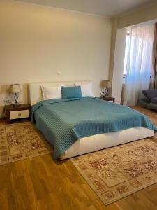 ママイア・ノルドにあるParliament Square Mamaia Nordのベッドルーム1室(大型ベッド1台、青い毛布付)