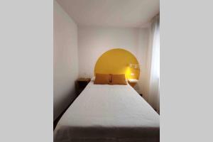 sypialnia z łóżkiem z żółtym zagłówkiem w obiekcie Avenida 37 w mieście Caldas de Reis