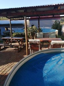 a swimming pool with a table and chairs and a table and a swimming poolintendent at Swartberg Guest House in Caledon