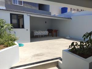 a patio of a white house with a table at Zoe House in Paul do Mar