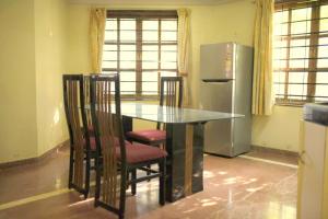 a kitchen with a table and chairs and a refrigerator at Anna's Bungalow 4BHK in Alibaug