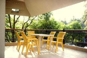 a table and chairs sitting on a balcony at Anna's Bungalow 4BHK in Alibaug