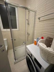 een wasmachine in een badkamer met een douche bij Central Modern Apartment in Il-Gżira