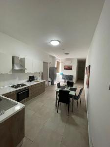 a kitchen and living room with a table and chairs at Central Modern Apartment in Il-Gżira