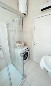 een badkamer met een douche en een wasmachine bij Central Modern Apartment in Il-Gżira