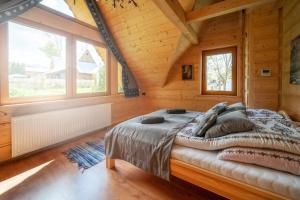 ein Schlafzimmer mit einem Bett in einer Holzhütte in der Unterkunft Domek Góralski Modrzewiowa Weranda in Zakopane