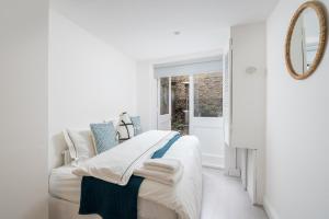 Habitación blanca con cama y espejo en Russell Sq Suite - 2 Bed Apartment en Londres