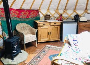 a room with a stove in a yurt at Cotswolds Camping at Holycombe in Shipston on Stour
