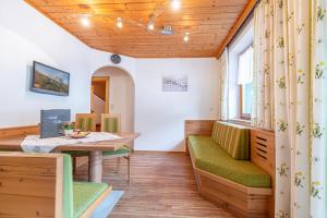a room with a table and chairs and a wooden ceiling at Moarbauer in Dorfgastein