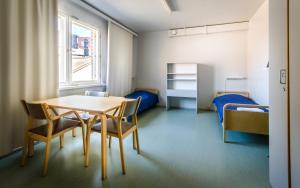 a room with a table and chairs and two beds at Eurohostel in Helsinki