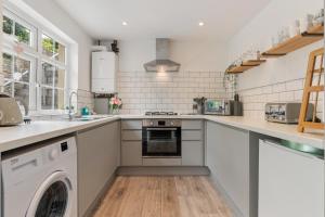 a kitchen with a washer and dryer in it at Ivydene - Beautiful Cottage, Stone Throw from Beach, Wonderful Sea Views in Saundersfoot +18 photos