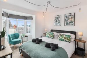 a bedroom with a bed and a blue chair at Ivydene - Beautiful Cottage, Stone Throw from Beach, Wonderful Sea Views in Saundersfoot