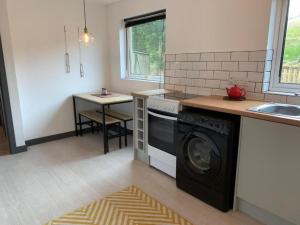 a kitchen with a washing machine and a sink at 3 Bed House - Sleeps 5 - Pets - Parking - Wifi in Oldshoremore +3 photos