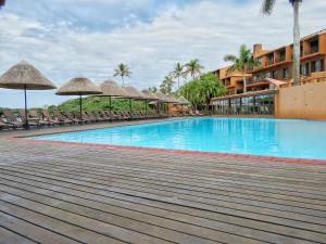 a swimming pool with chairs and umbrellas in a resort at Lot 25 SM06 in Southbroom