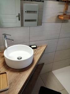 baño con lavabo blanco en una encimera de madera en Maison à la campagne en Lyaud