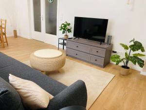 een woonkamer met een bank en een flatscreen-tv bij Apartment am Kurpark in Wilhelmshaven