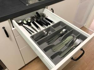 een gootsteen met keukengerei in een lade bij Apartment am Kurpark in Wilhelmshaven