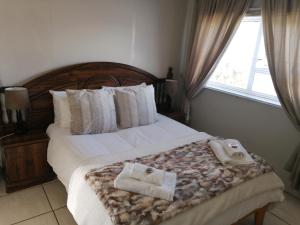 a bedroom with a bed with two towels on it at Swartberg Guest House in Caledon
