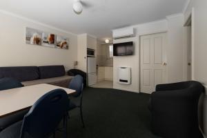 a living room with a couch and a table and chairs at Barclay Motor Inn in Devonport