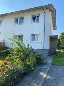 a white house with a door and a sidewalk at WOHNUNG OBERGESCHOSS mit 3 Schlafzimmer in ruhiger Gegend in Mäder