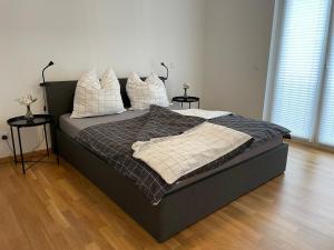Un dormitorio con una cama grande con almohadas. en Emerald Green Apartment, en Offenbach
