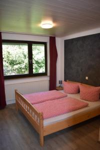ein Schlafzimmer mit einem großen Bett mit roten Kissen in der Unterkunft Hotel Engelbracht inklusive MeineCardPlus in Willingen