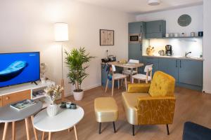 uma sala de estar com uma cozinha e uma sala de estar com um sofá em Domitys Les Houblons em Brest