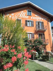 un edificio naranja con flores delante en Alba Camere Chiomonte, en Chiomonte